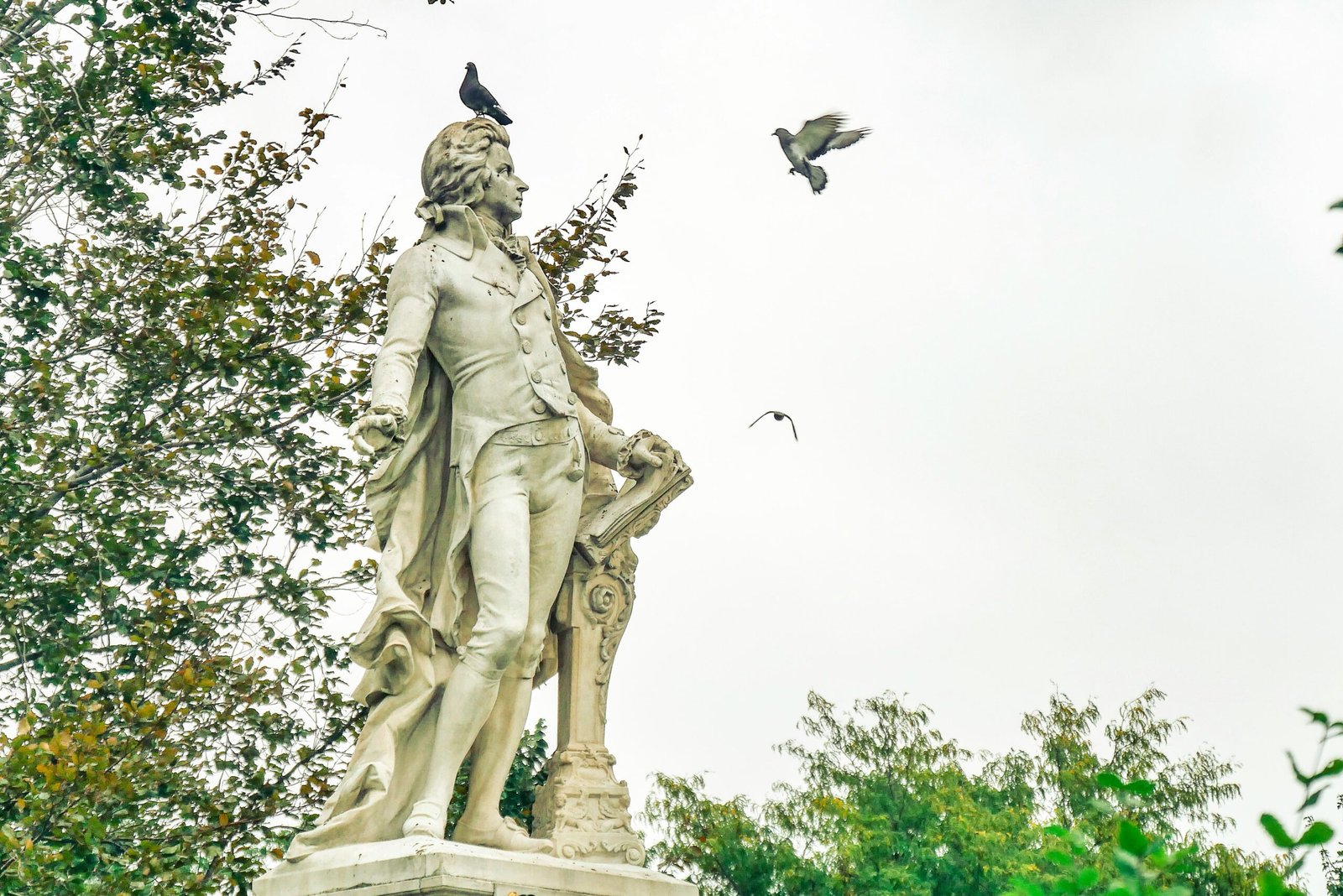 a statue of a man with a bird on his shoulder