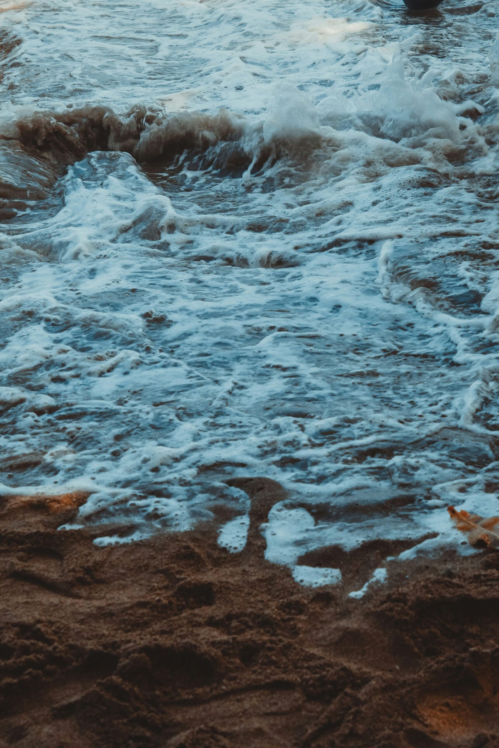 a man standing on a beach next to the ocean
