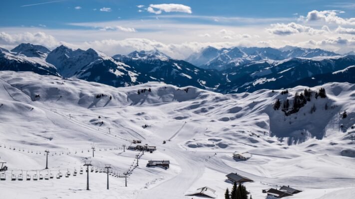 Panoramic view of Kitzbühel in the Austrian Alps with snow-covered peaks and a charming historic center.