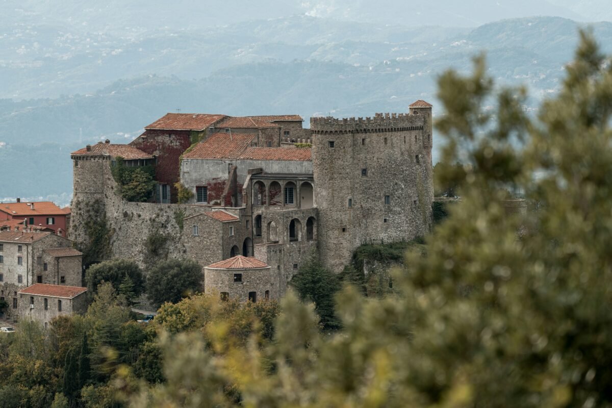 an old castle sits on top of a hill