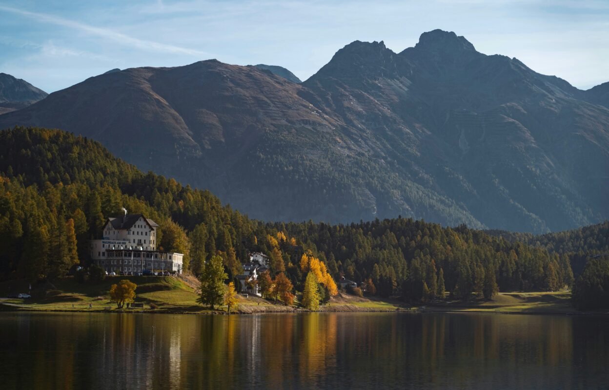 a house on a lake surrounded by mountains a house on a lake surrounded by mountains