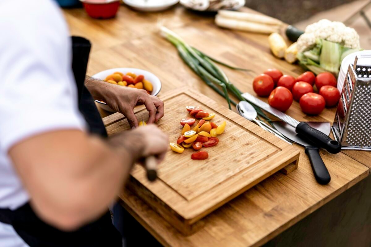 a person cutting up vegetables on a cutting board a person cutting up vegetables on a cutting board