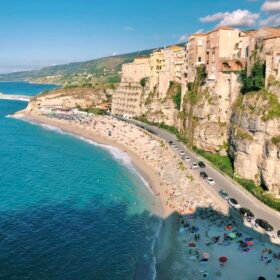 an aerial view of a beach with a cliff in the background